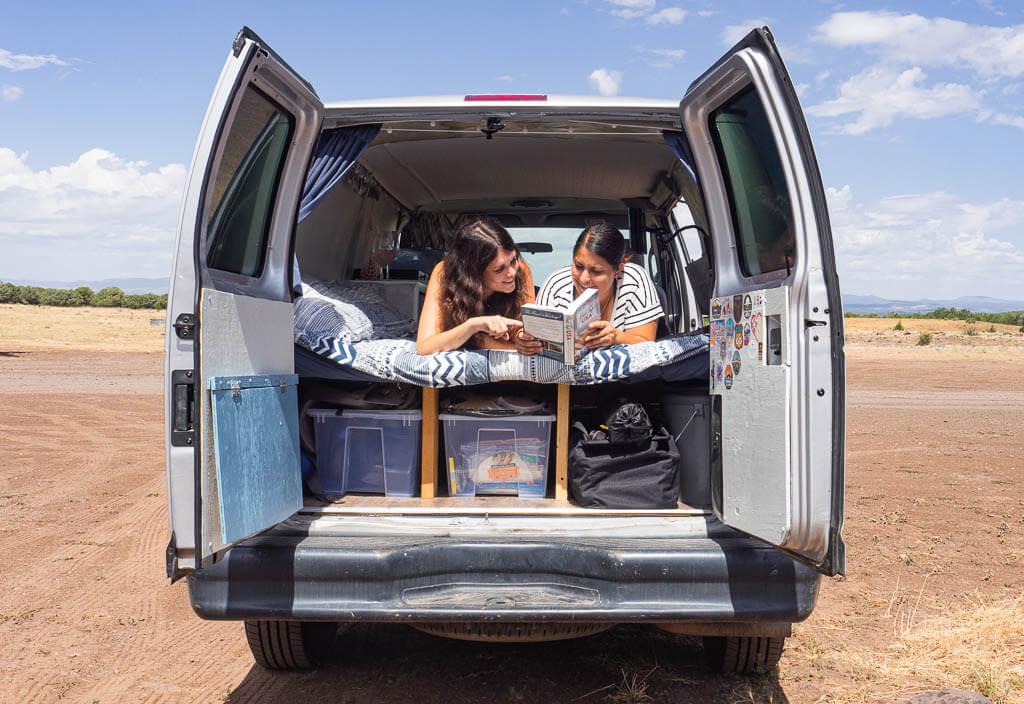 Us laying in our camper van planning our next adventure