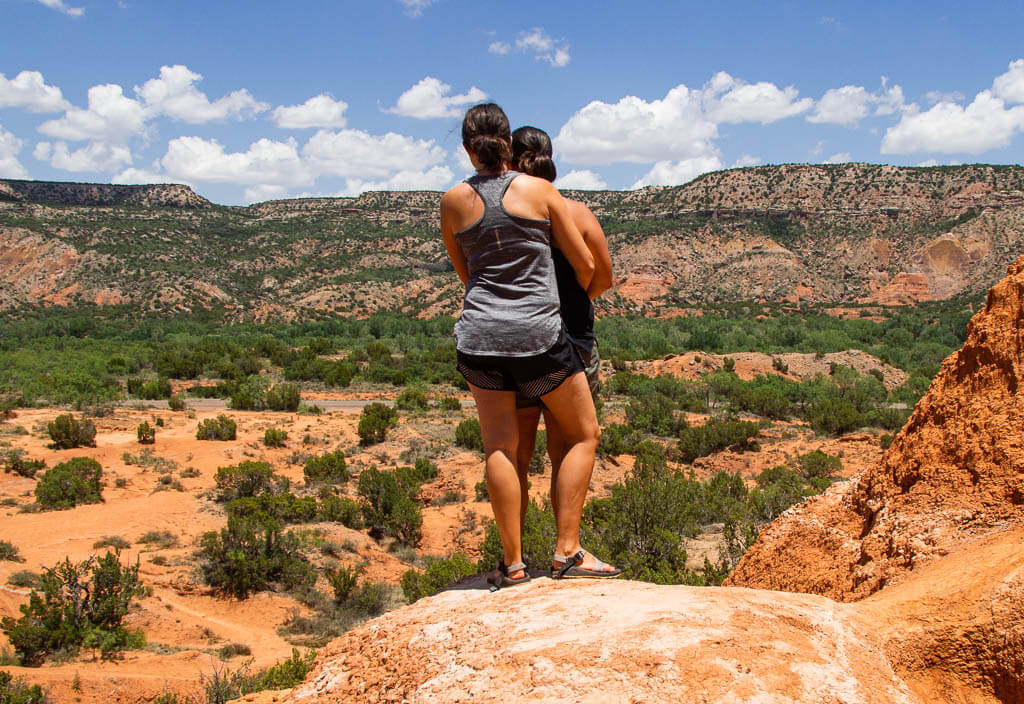 Us standing on a rock overlooking the desert landscape in Arizona