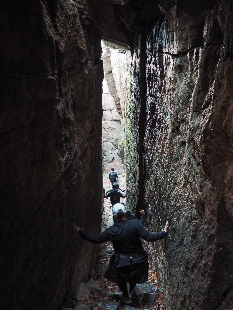 Hiking on a narrow path between two huge boulders