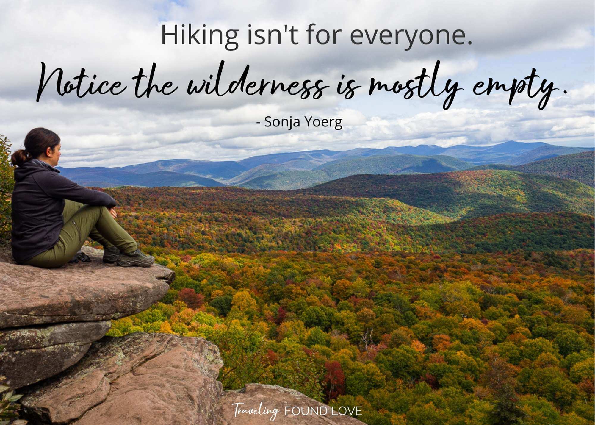 Dana sitting on the edge of a rock overlooking the colorful fall foliage in New York