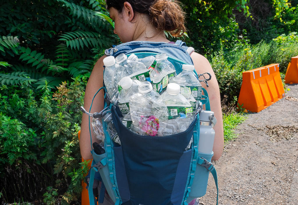 Dana carrying a backpack full of empty water bottles after hiking Breakneck Ridge