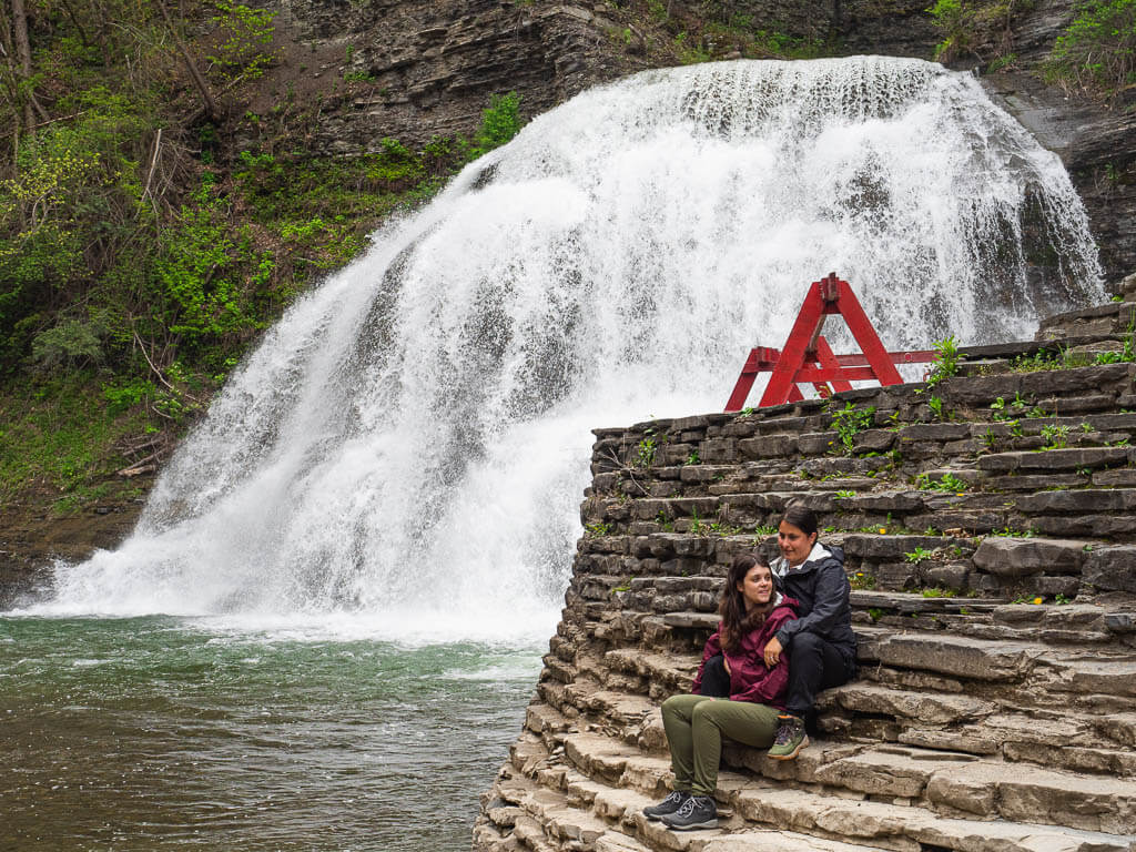 Us sitting in front of Lower Falls in Robert H. Treman State Park, one of the best waterfalls in NY to swim in