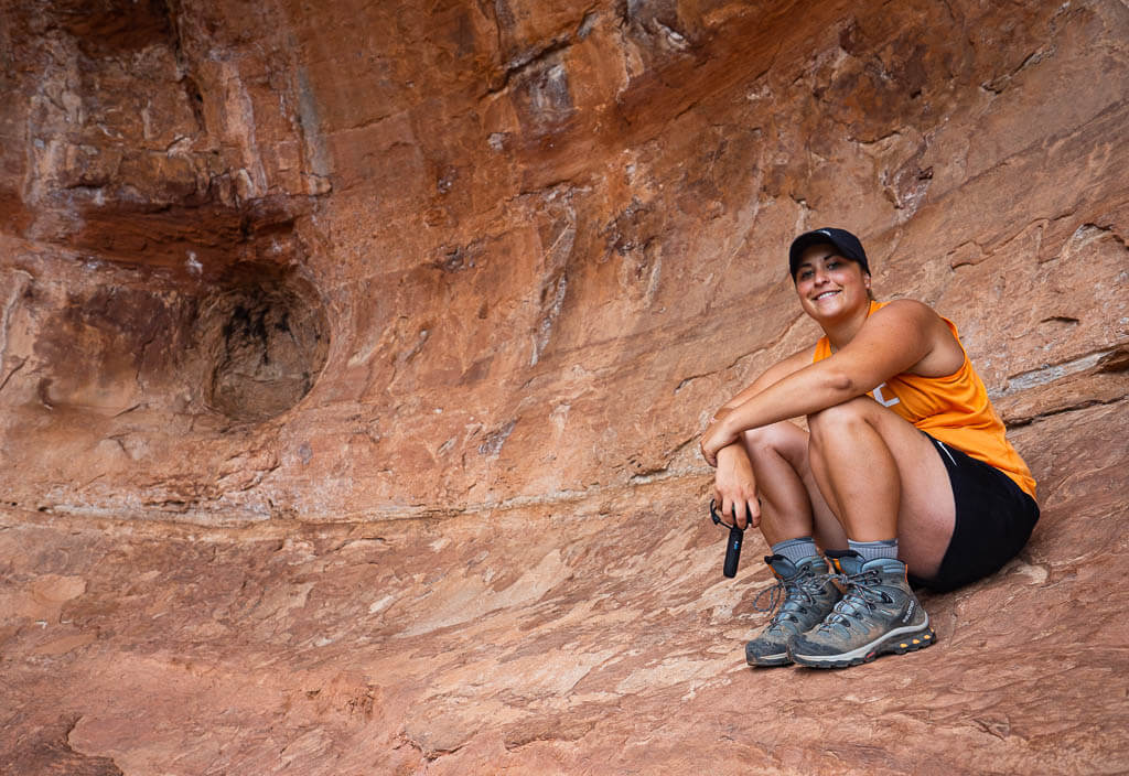 Rachel sitting next to a hole in the Birthing Cave Sedona