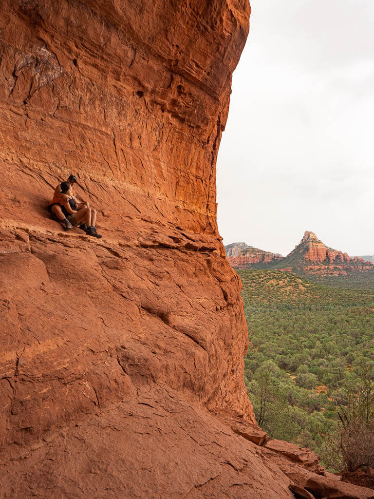 Rachel and Dana sitting on the edge of Birthing Cave Sedona