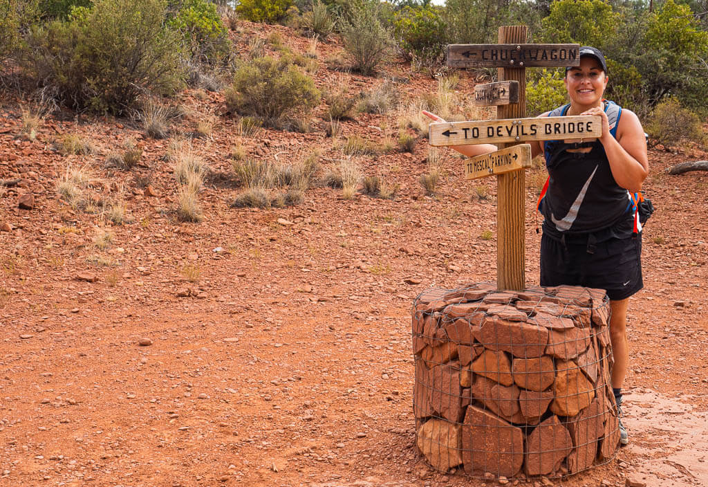 Rachel standing at the Devils Bridge Sedona sign post