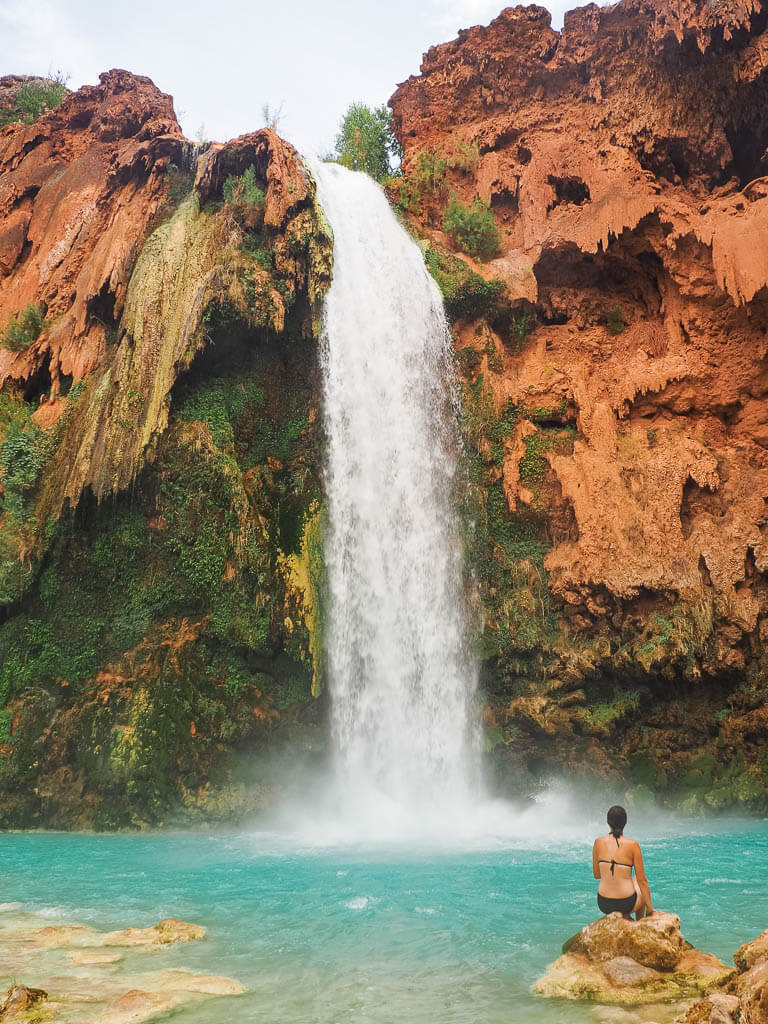 Dana sitting on a rock in front of Havasu Falls