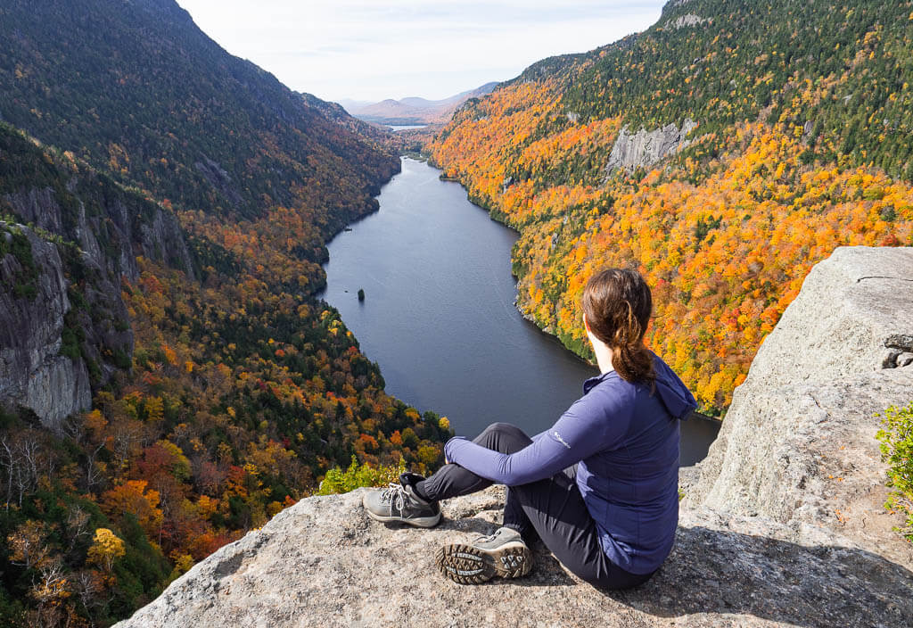 Dana sitting on a rock overlooking Lower Ausable Lake