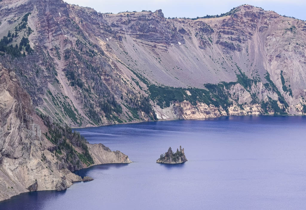 Blueish crater Lake with crater formation in the background
