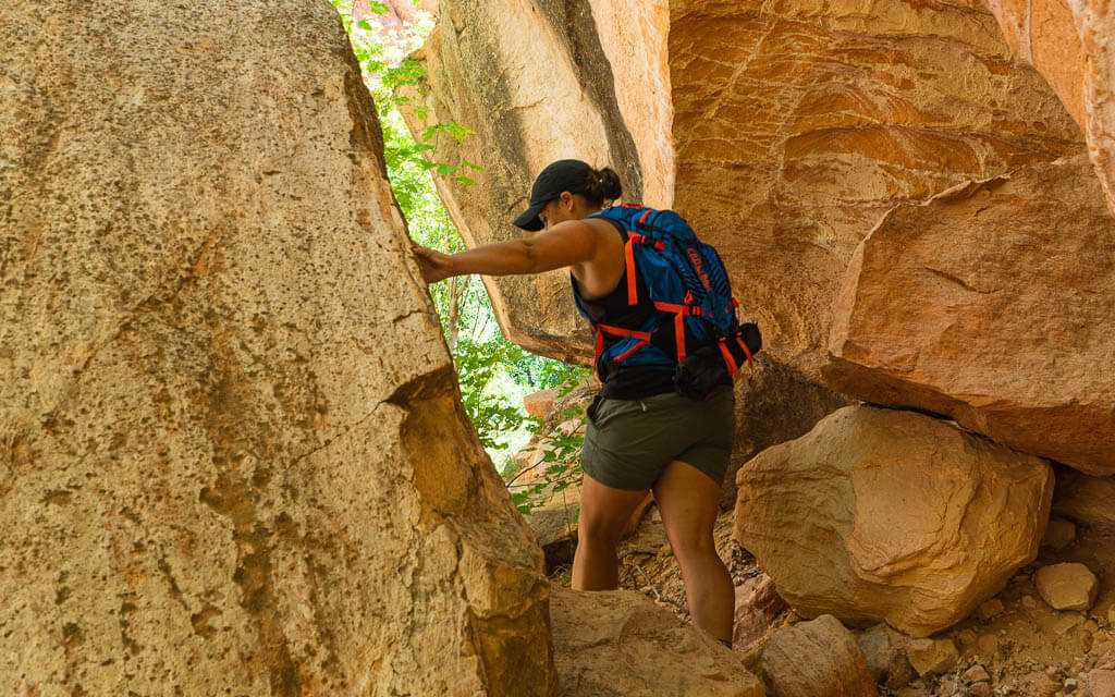 Rachel hiking between two big boulders