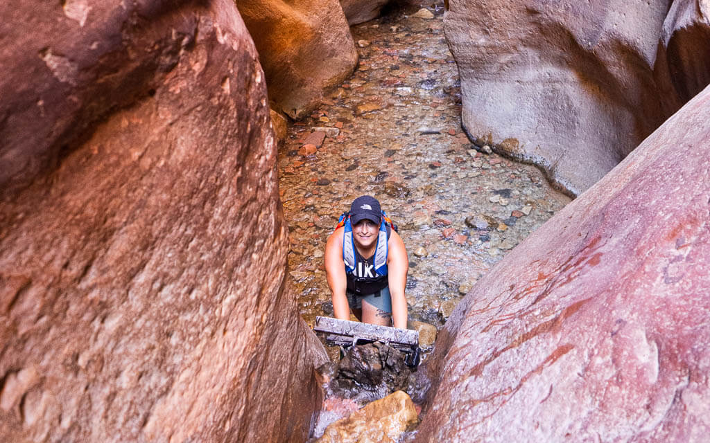 Rachel climbing up the ladder next to the first Kanarra Falls waterfall