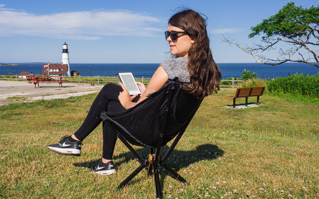 Dana sitting in a Cliq Chair reading her kindle