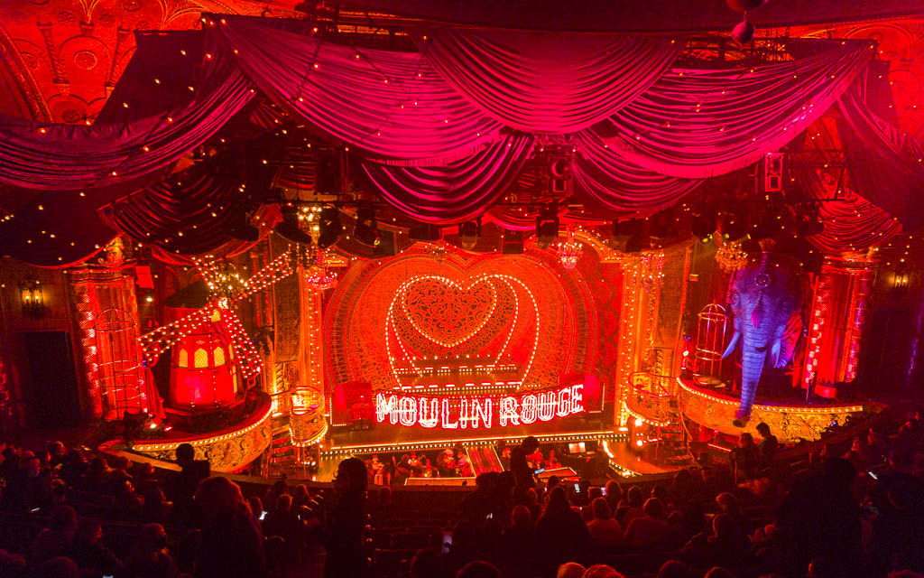 Stage of the Moulin Rouge Musical and people following the Broadway dress code