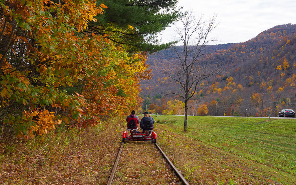Two people riding the rail bikes during fall in upstate New York