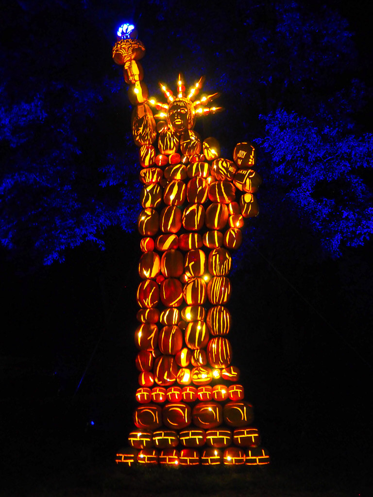 Lit up, carved pumpkins resembling the Statue of Liberty